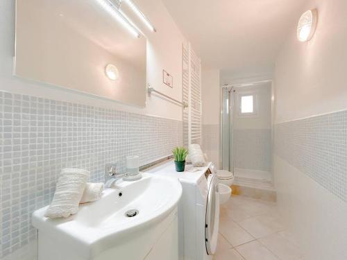 a white bathroom with a sink and a toilet at Casa Vico Mandorla in Savona