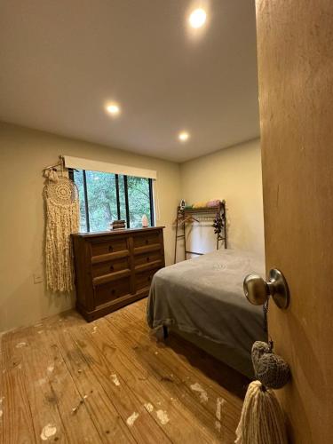 a bedroom with a bed and a dresser and a window at Melmac in Sauce de Portezuelo