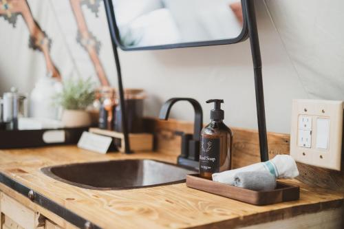 a sink with a bottle of soap and a mirror at Toro Tipi at El Mistico Ranch in Nogal