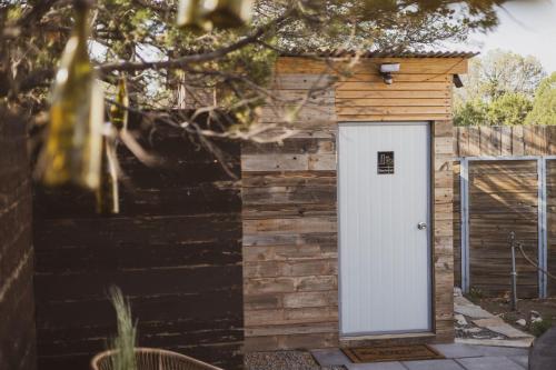 a small wooden shed with a white door at Toro Tipi at El Mistico Ranch in Nogal