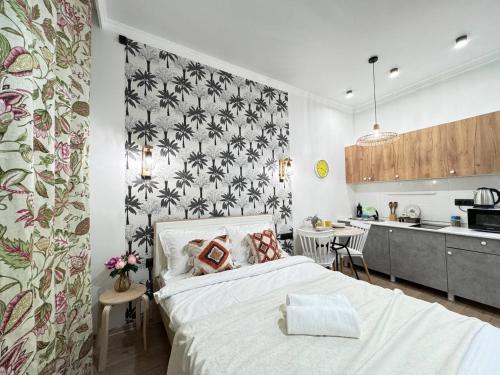 ein Schlafzimmer mit einem Bett und einer Küche in der Unterkunft EmmaApart Comfort 11 in Astana