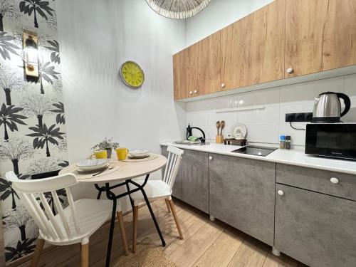 eine Küche mit Tisch und Stühlen und einer Uhr in der Unterkunft EmmaApart Comfort 11 in Astana