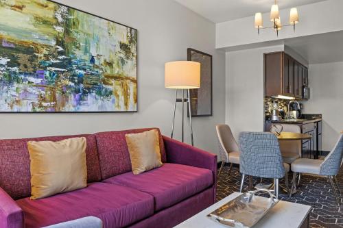 a living room with a purple couch and a painting at Deluxe Union Square Suites in San Francisco