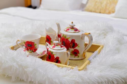 bandeja con 2 tazas y set de té en una cama en Itele guest house, en Itele