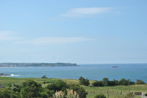 a view of the ocean with a boat in the water at El Ribero de Langre in Langre