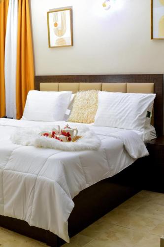 Una cama con sábanas blancas y un animal de peluche. en Itele guest house, en Itele