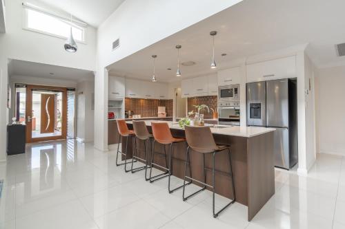 a kitchen with a large island with bar stools at 8 min to beach, Sleep 12 and Pets in Port Macquarie