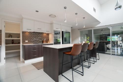 a kitchen with a large island with bar stools at 8 min to beach, Sleep 12 and Pets in Port Macquarie