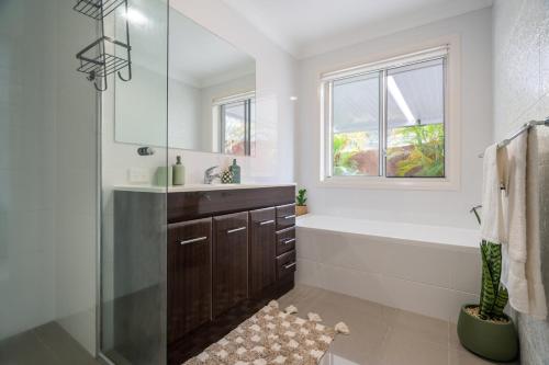 a bathroom with a tub and a sink and a shower at 8 min to beach, Sleep 12 and Pets in Port Macquarie