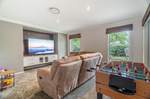 a living room with a couch and a foosball table at 8 min to beach, Sleep 12 and Pets in Port Macquarie