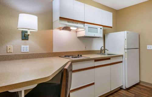 a kitchen with white cabinets and a white refrigerator at Extended Stay America Suites - Orlando - Altamonte Springs in Orlando
