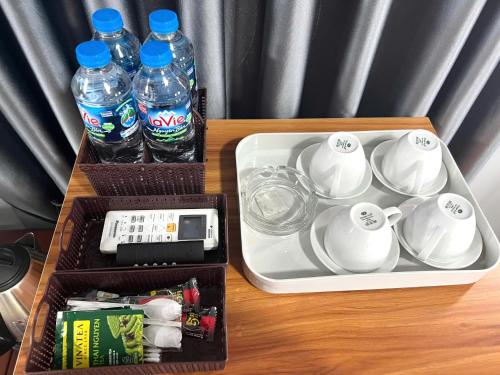 a table with a tray with cups and water bottles at Khách Sạn Trung Anh 78 HAI BÀ TRƯNG BMT in Buon Ma Thuot