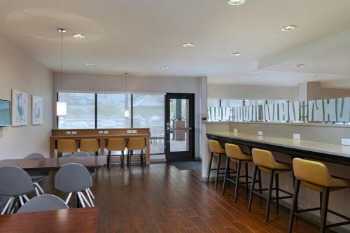 a restaurant with a bar with chairs and tables at TownePlace Suites by Marriott Macon Mercer University in Macon