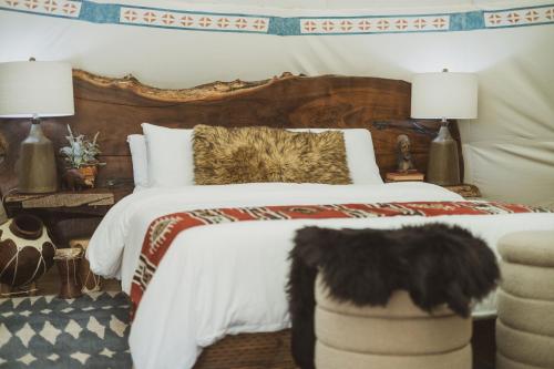 a bedroom with a bed with a black dog sitting on it at Oso Tipi at El Mistico Ranch in Nogal