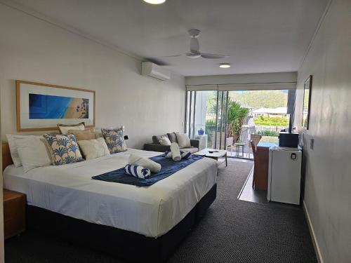 a bedroom with a large bed and a living room at Water Views Studio in Nelly Bay