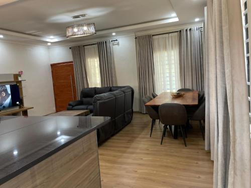 a living room with a couch and a dining room table at Ruby's Haven in Lusaka