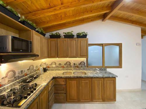 a kitchen with wooden cabinets and a counter top at Fraternity Room - a solo una cuadra del parque in Carmen de Viboral