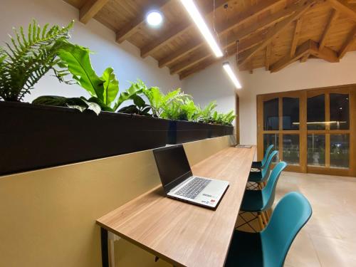 a laptop computer sitting on a wooden table with chairs at Fraternity Room - a solo una cuadra del parque in Carmen de Viboral