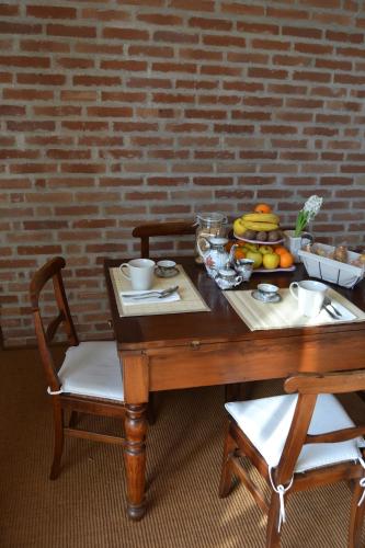 a wooden table with a bowl of fruit on it at Tenuta Ajrale in Vigone