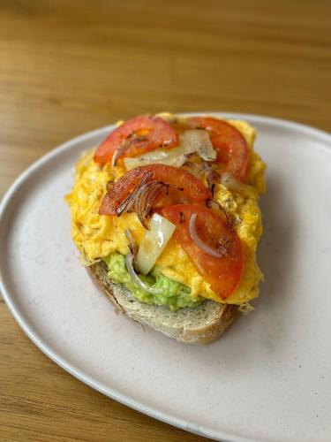 a sandwich with tomatoes on a plate on a table at Rin Bay View Resort in Haad Rin