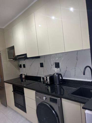 a kitchen with white cabinets and a washing machine at 10 Lagoon Cabanas Ramsgate in Margate