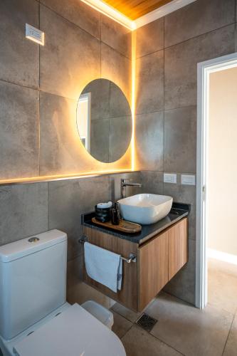 a bathroom with a sink and a toilet and a mirror at Tylluan Lodge in Trevelín