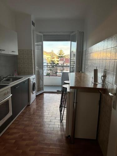 - une cuisine avec un évier et un comptoir avec une table dans l'établissement Orangers Apartment, à Nice