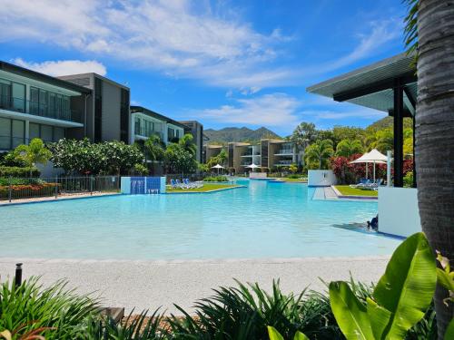 a swimming pool at a resort with buildings at Water Views Studio in Nelly Bay