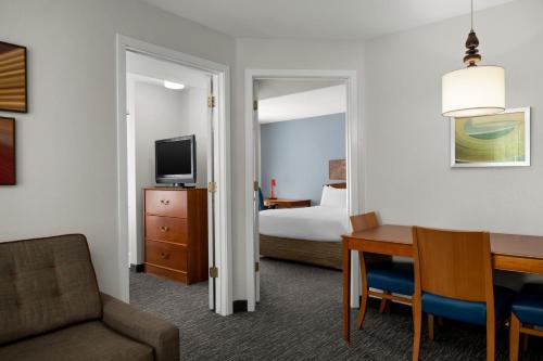a hotel room with a bed and a dining room at TownePlace Suites Salt Lake City Layton in Layton