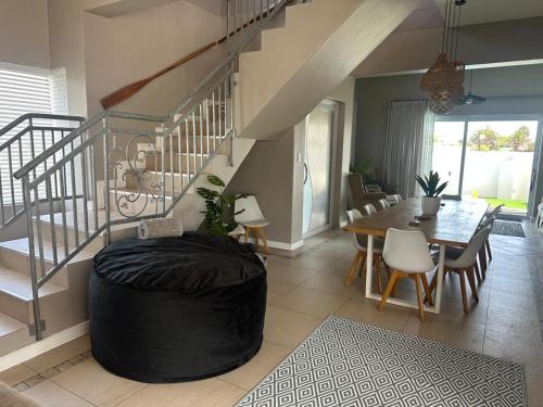 a large living room with a table and a staircase at Luxury Beachfront Villa in Langebaan