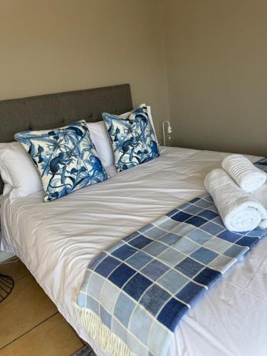 a bed with blue and white pillows on it at Luxury Beachfront Villa in Langebaan