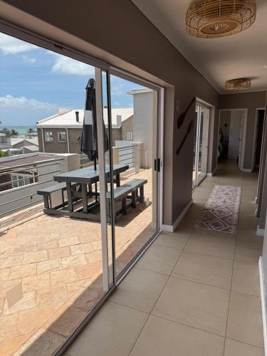 a balcony with a bench and a picnic table on a patio at Luxury Beachfront Villa in Langebaan
