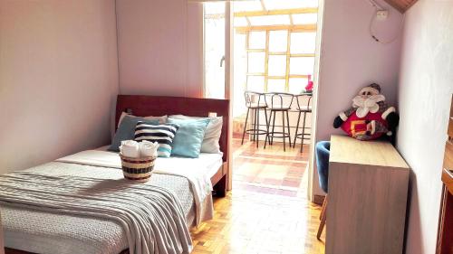 a bedroom with a bed and a table with a stuffed animal at GUAYACÁN Apartamento duplex en centro histórico de Tunja con 2 terrazas in Tunja