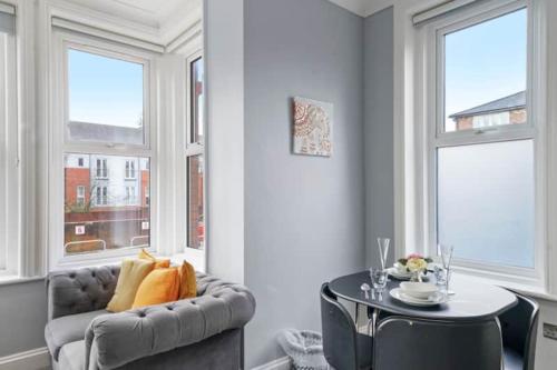a living room with a couch and a table and windows at BridgeCity Glamorous studio Free Parking in Maidstone Town in Kent