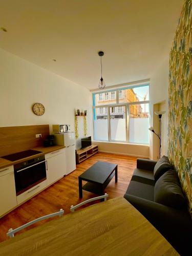 un salon avec un canapé et une cuisine dans l'établissement Les Perles d'Opale - Le Petit Sablé - Hyper centre, à Boulogne-sur-Mer