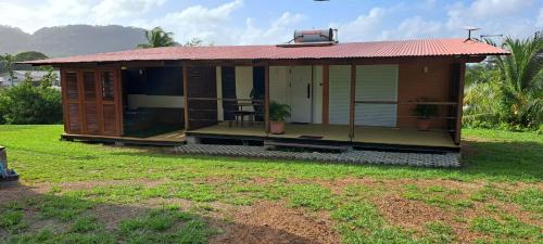 a small house with a red roof and a yard at Les Maripas T2 in Rémiré