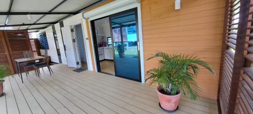 a porch with a potted plant and a glass door at Les Maripas T2 in Rémiré