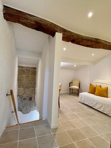 une chambre avec un lit et un mur en pierre dans l'établissement Renovated village house in peaceful town near Med - Air conditioning, balcony, à Pomérols