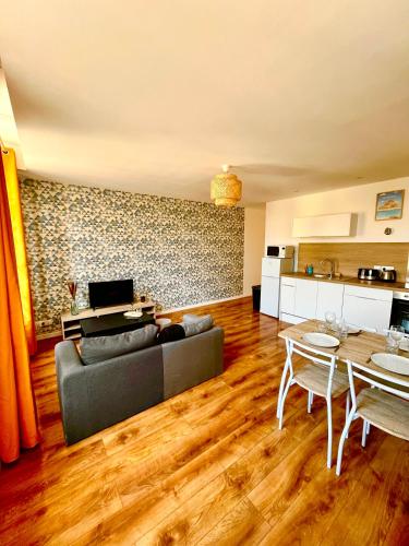 un salon avec un canapé et une table dans l'établissement Les Perles d'Opale - L'Horizon Bleu - Hyper centre, à Boulogne-sur-Mer