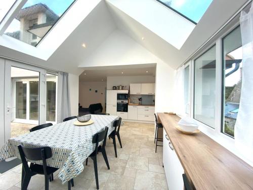 une cuisine et une salle à manger avec une table et des chaises dans l'établissement Maison neuve proche plage à Trégastel avec WIFI et parking - FR-1-368-440, à Trégastel