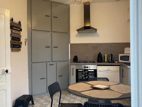une cuisine avec une table et des chaises dans une cuisine dans l'établissement Gîte familial au calme avec jardin clos, près d'Orléans - FR-1-590-532, à Vieilles-Maisons-sur-Joudry