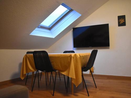 Cette chambre dispose d'une table avec des chaises et d'une télévision à écran plat. dans l'établissement Studio cabine cosy pour 3, proche des pistes de ski Pyrénées 2000 - FR-1-592-74, à Font-Romeu