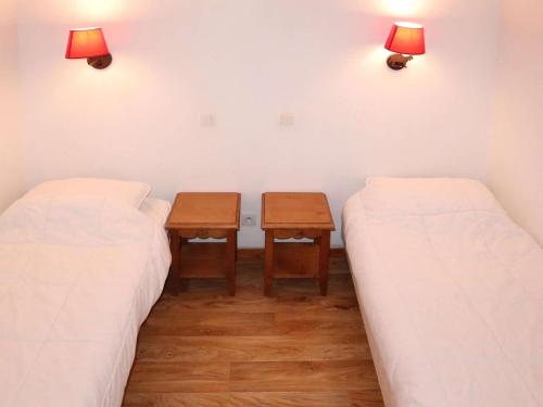 deux lits dans une chambre avec deux tables et des lumières dans l'établissement Apt 2 pièces Les Orres 1800 avec piscine, sauna, animaux admis - FR-1-322-663, aux Orres