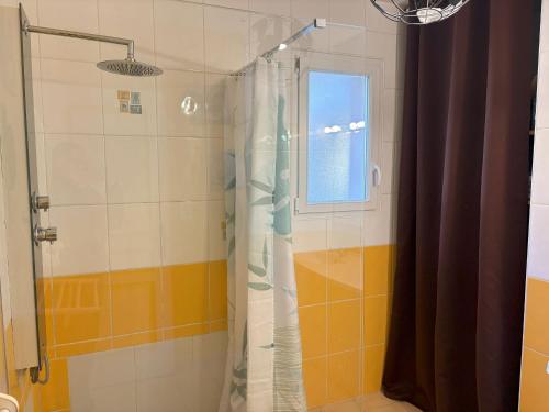 La salle de bains est pourvue d'une douche avec un rideau de verre. dans l'établissement Maison aux portes de la forêt avec piscine privée, Wi-Fi et animaux admis - FR-1-323-558, à Saint-Jean-de-Monts