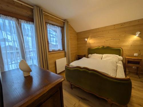 une chambre avec un lit et un mur en bois dans l'établissement Appartement rénové pied des pistes - 2 ch - 6 pers - Parking - Arêches-Beaufort - FR-1-342-324, à Beaufort