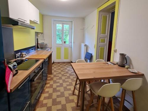 a kitchen with a wooden table and chairs in it at Charmant gîte entre Nancy et Metz avec terrasse - FR-1-584-362 in Belleville