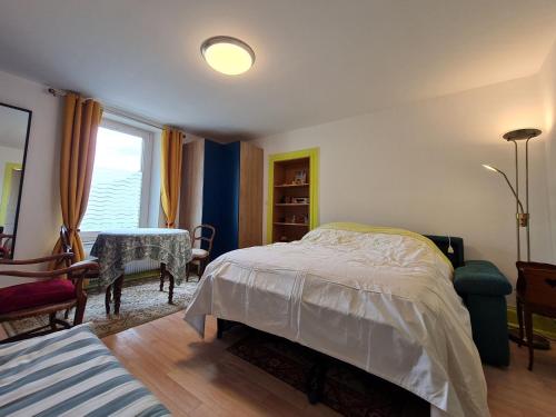 a bedroom with a bed and a table and a window at Charmant gîte entre Nancy et Metz avec terrasse - FR-1-584-362 in Belleville