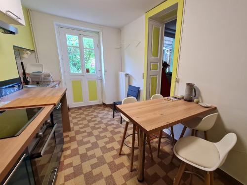 a kitchen with a wooden table and chairs at Charmant gîte entre Nancy et Metz avec terrasse - FR-1-584-362 in Belleville