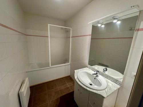 une salle de bain avec un lavabo et un miroir dans l'établissement T3 aux Angles: 6 pers, parking, animaux admis - FR-1-758-35, aux Angles