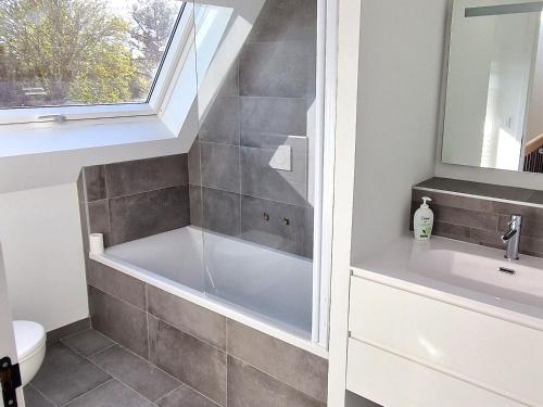 ein Badezimmer mit Badewanne und Waschbecken in der Unterkunft Maison rénovée cœur de Groix, 9 couchages - FR-1-813-13 in Groix